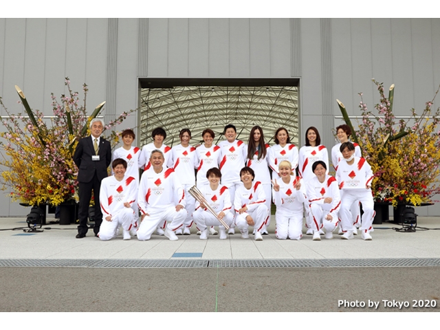 Members of 2011 Nadeshiko Japan serve first runner of the Olympic torch relay